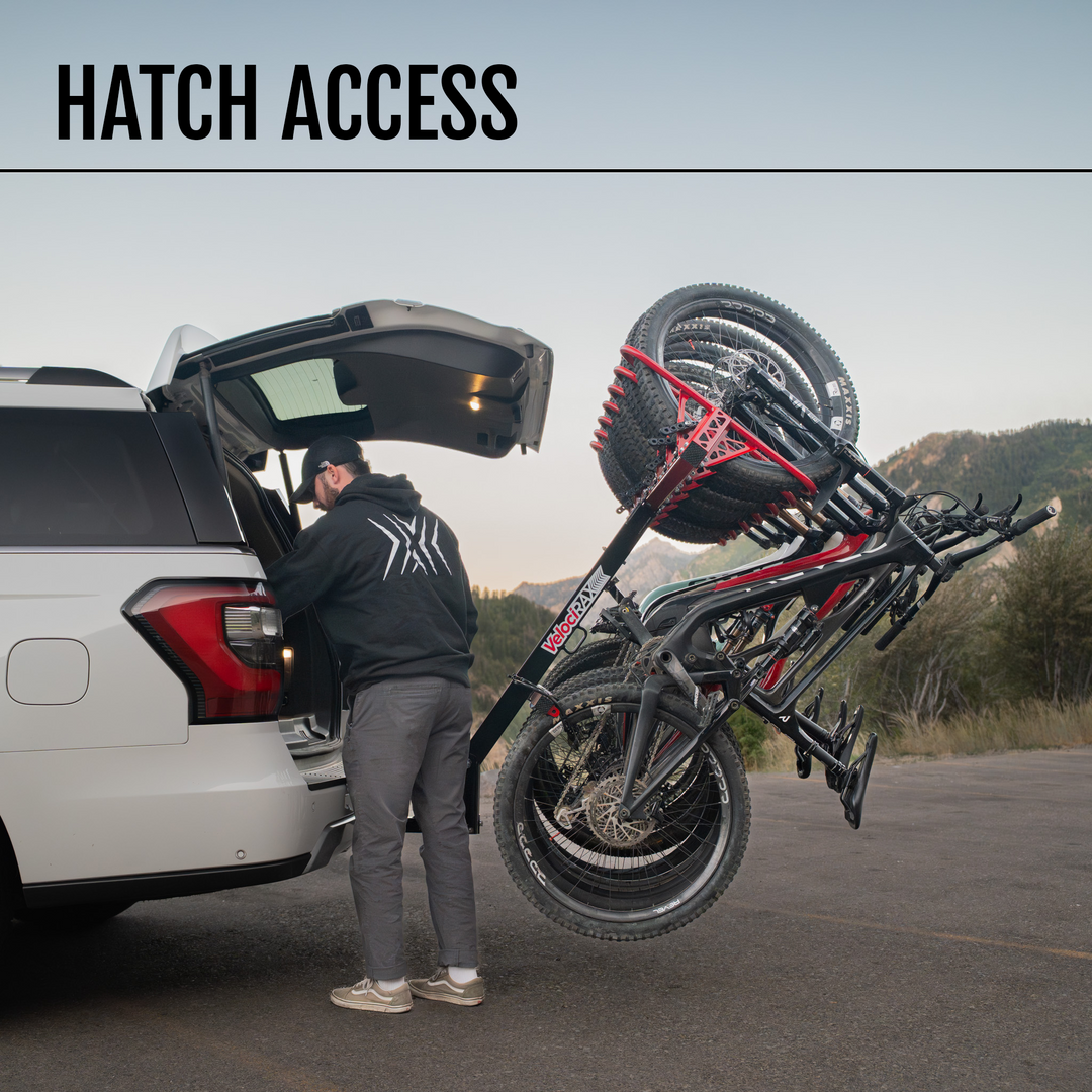 Person accessing the rear hatch of a car with attached MAX rack with 'Hatch Access' text above.